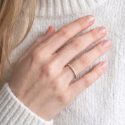 Woman wearing DEMAIN Diamonds Platinum eternity band ring set with lab grown diamonds on ring finger - lifestyle view